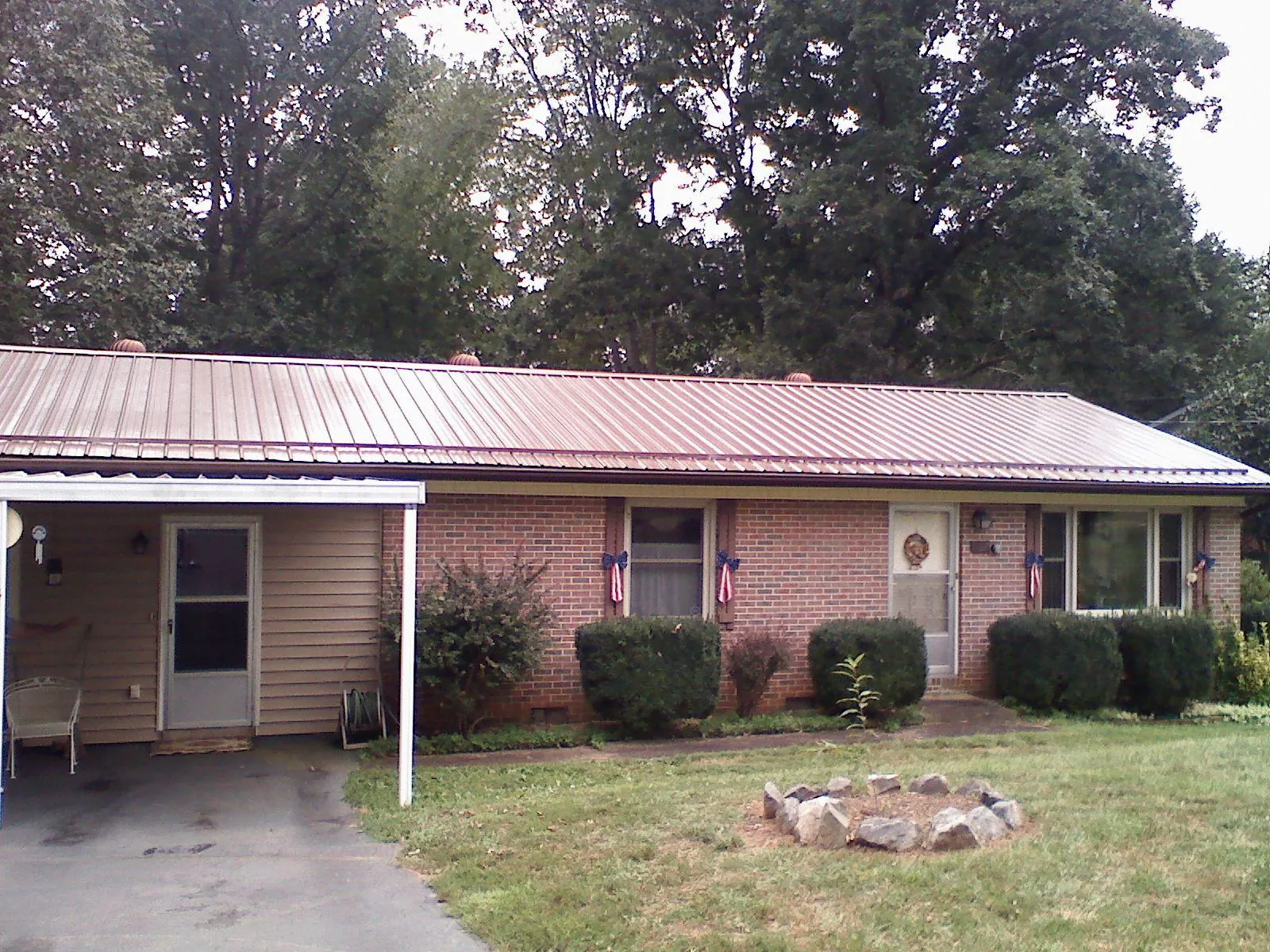 Bronze metal roof and carport on a brick ranch home — Roof Repair work by our crew in Live Oak